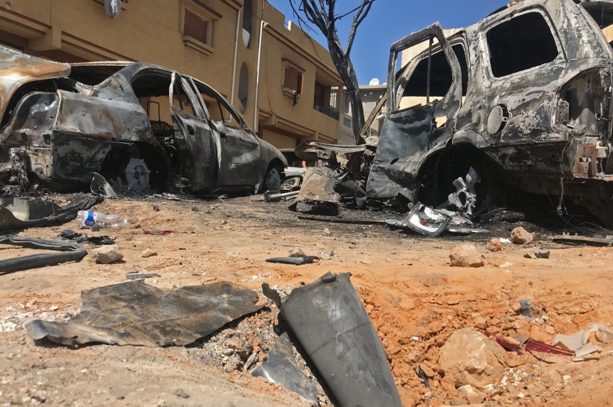 A picture taken on April 17, 2019 shows remnants of a rocket and burnt vehicles at the scene of an overnight rocket attack which no group claimed responsibility for so far in the Libyan capital Tripoli. [Mahmud TURKIA / AFP / Getty]