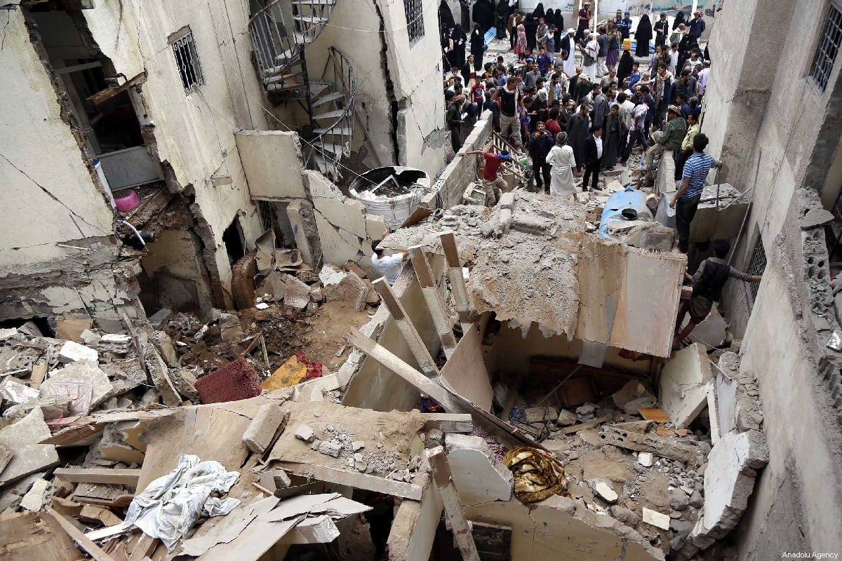 People gather round damaged buildings after the Saudi-led military coalition carried our air strikes in Sanaa, Yemen on 16 May 2019 [Mohammed Hamoud/Anadolu Agency]