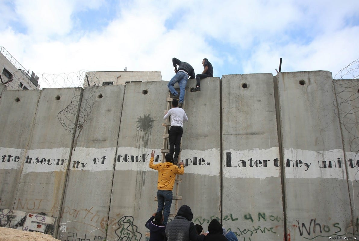 Palestinians climb the ladder to cross the separation wall and reach Jerusalem in order to perform the first Friday Prayer of Islamic holy month of Ramadan at the Al-Aqsa Mosque, after Israeli authorities' don't allow men under 40 years old for the passage, in the Al-Ram town of Jerusalem, on 10 May, 2019 [Issam Rimawi/Anadolu Agency]