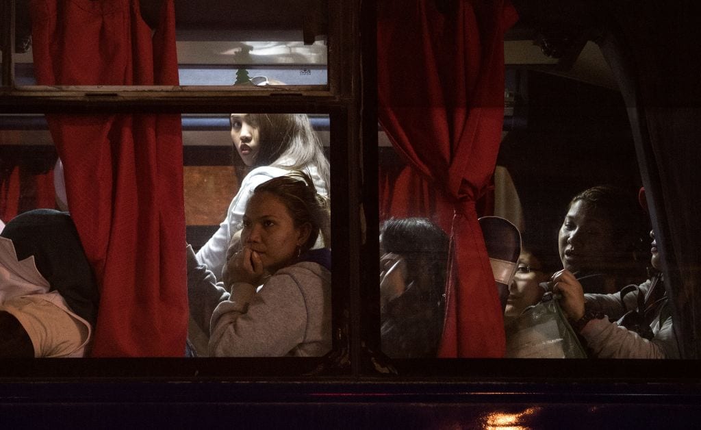 Filipina workers returning home from Kuwait inside a bus after arriving at Manila International Airport on 17 February 2018. [NOEL CELIS/AFP/Getty Images]