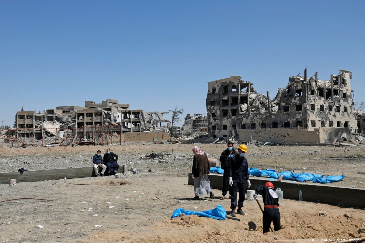 Syrians recover bodies that were found in a mass grave in Raqqa, Syria on 23 April 2018 [DELIL SOULEIMAN/AFP/Getty Images]