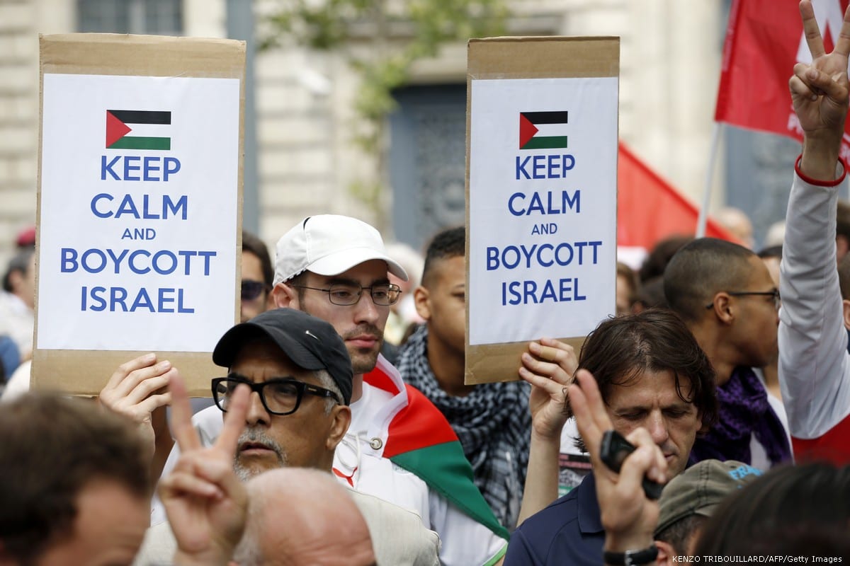A Pro-Palestinian demonstrators carry placards reading 'Keep calm and boycott Israel' on 26 July 2014 [KENZO TRIBOUILLARD/AFP/Getty Images]