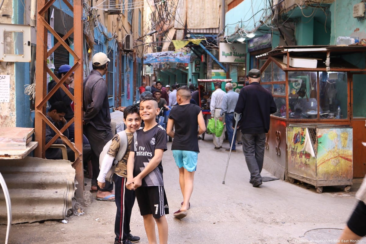 Two young boys smile and pose for the camera in Shatila camp