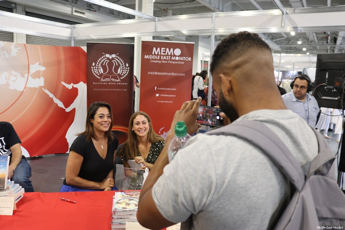 Palestinian chef Joudie Kalla seen at the MEMO stall signing copies of her latest cookbook "Baladi" at the Palestine Expo 2019 on 6 July 2019 in London, UK [Middle East Monitor]