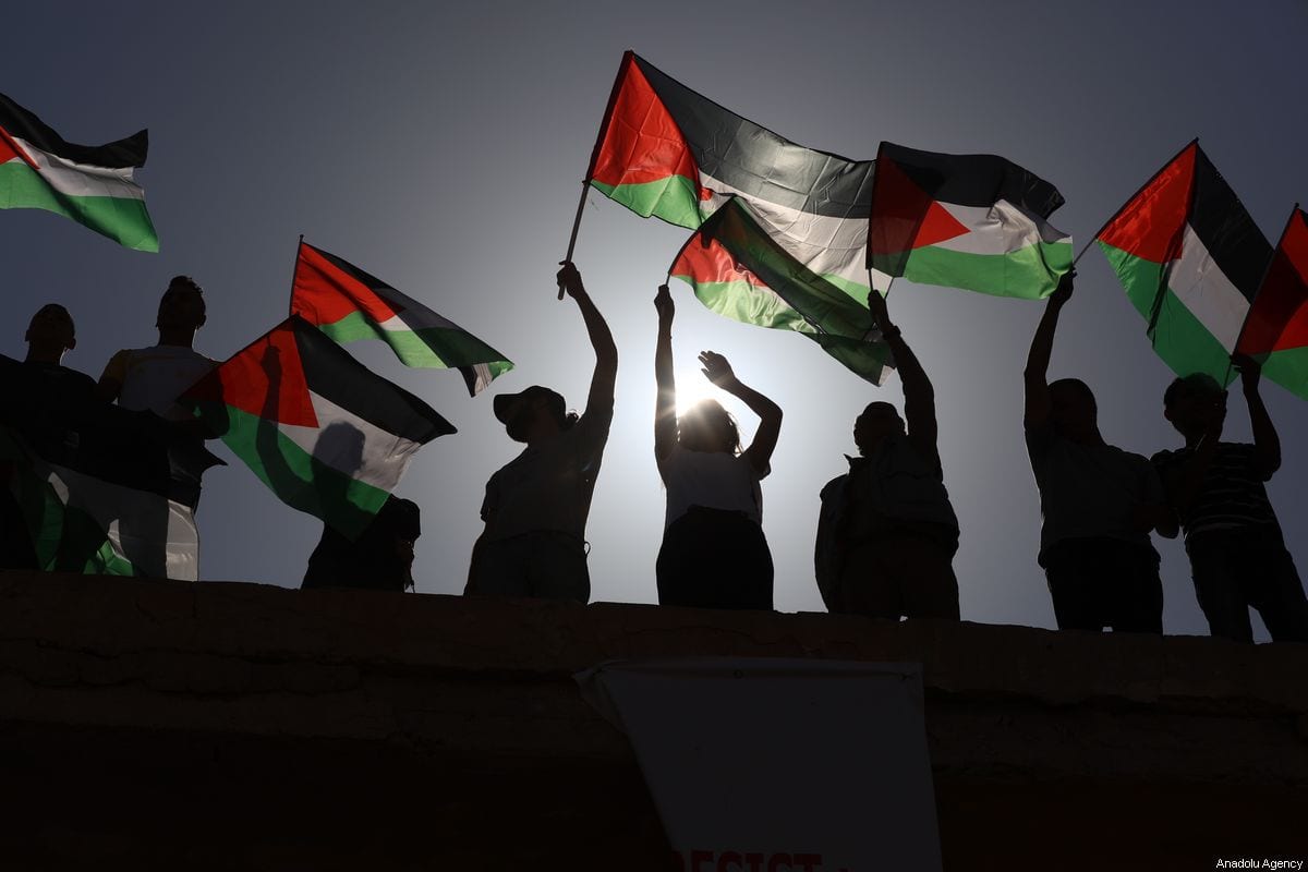 People hold Palestinian flags to protest against Israeli Prime Minister Benjamin Netanyahu in the West Bank on 28 September 2019 [Issam Rimawi/Anadolu Agency]