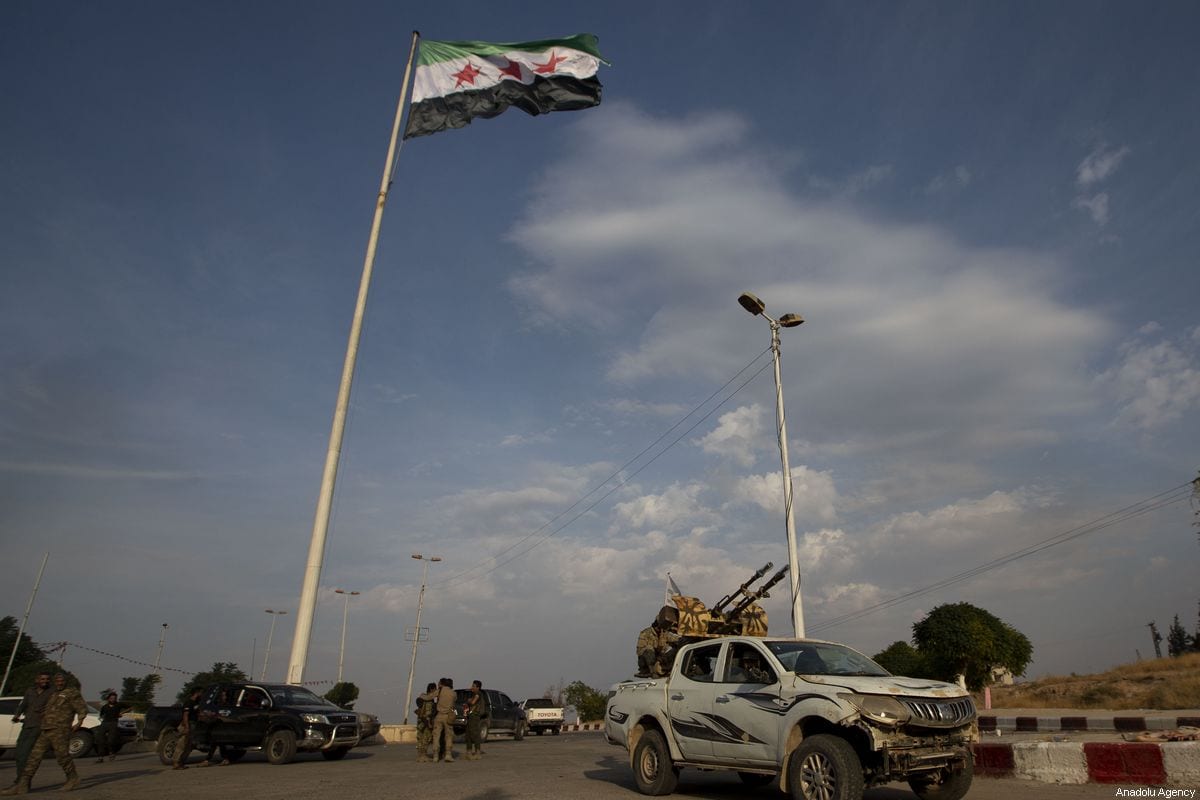 Syrian National Army (SNA) members hang a Syrian National Army flag on October 17, 2019 in Tal Abyad, Syria [Anadolu Agency/Anadolu Agency]