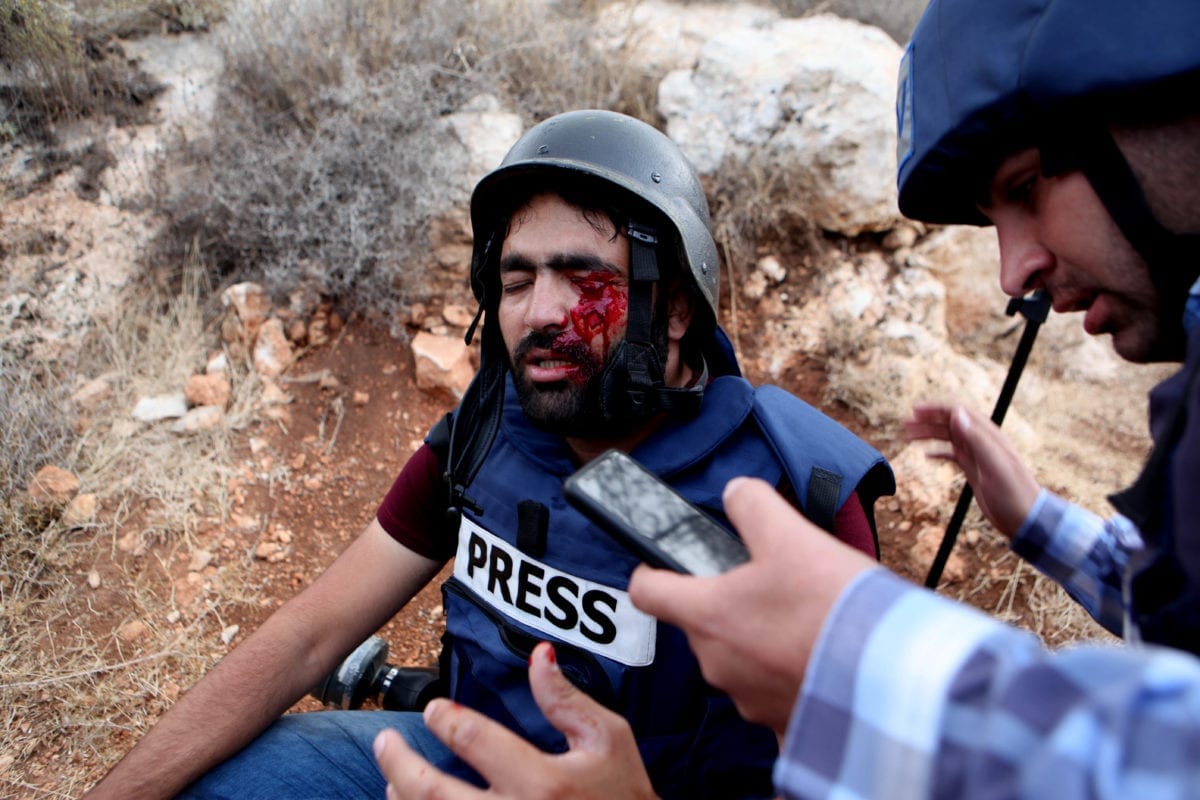 G Media photo-journalist Muath Amarneh is being carried away after being shot with rubber bullet from his eye by Israeli forces during a protest against separation wall and Jewish settlements in Hebron, West Bank on 15 November 2019. [Mamoun Wazwaz - Anadolu Agency]