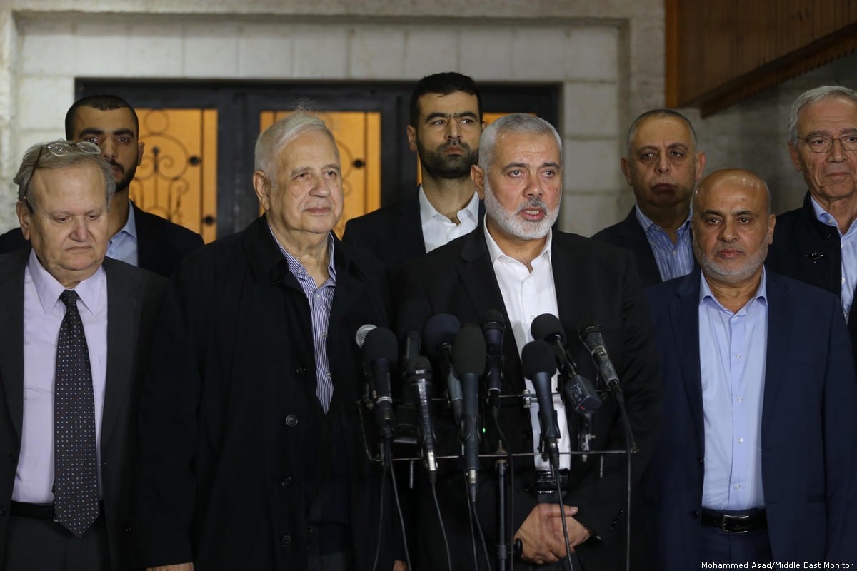 Hamas chief Ismail Haniyeh informs Hanna Nasser, head of the Palestinian Central Election Commission, that Hamas agrees to the plan for holding Palestinian elections [Mohammed Asad/Middle East Monitor]