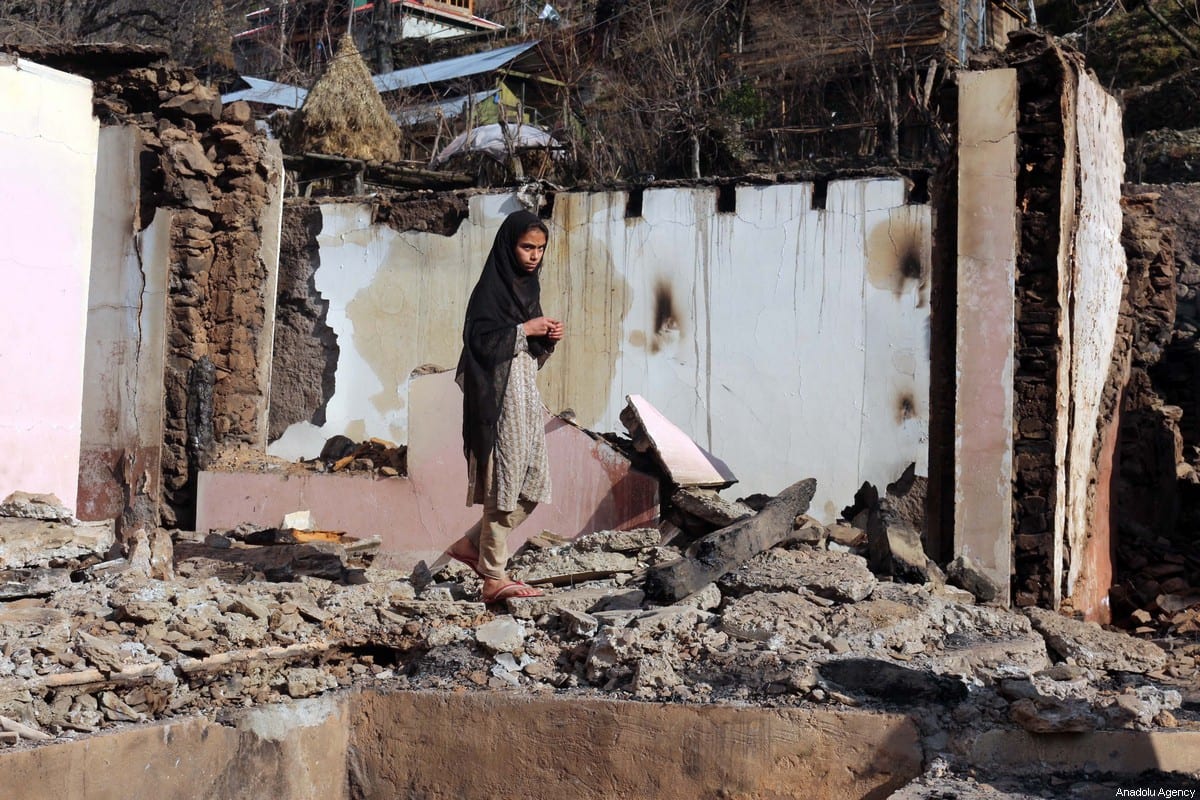 A woman stands on the debris of her house targeted by cross border Indian troops in Kashmir on 23 December 2019 [CHUDARY NASEER/Anadolu Agency]