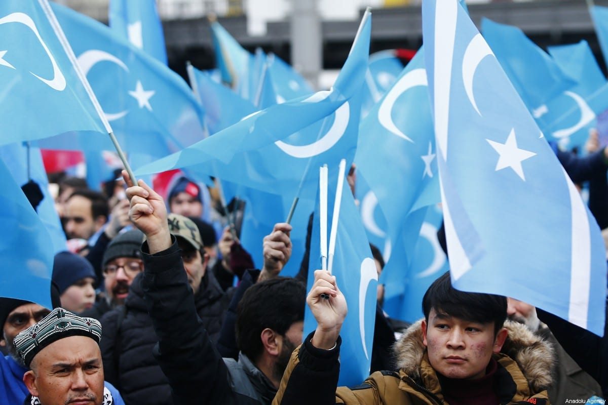 Demonstrators hold Uyghur flags as they take part in a demonstration in support of Uyghur Turks against human rights violations of China, in Berlin, Germany on 27 December 2019. [Abdulhamid Hoşbaş - Anadolu Agency]
