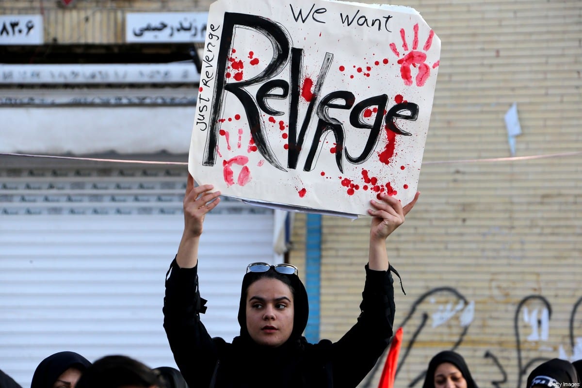 An Iranian mourner holds a placard after US forces killed Qasem Soleimani in an air strike in on 7 January 2020 [ATTA KENARE/AFP/Getty Images]