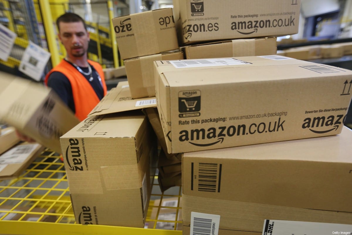 A worker prepares packages for delivery at an Amazon warehouse on September 4, 2014 in Brieselang, Germany [ Sean Gallup/Getty Images]