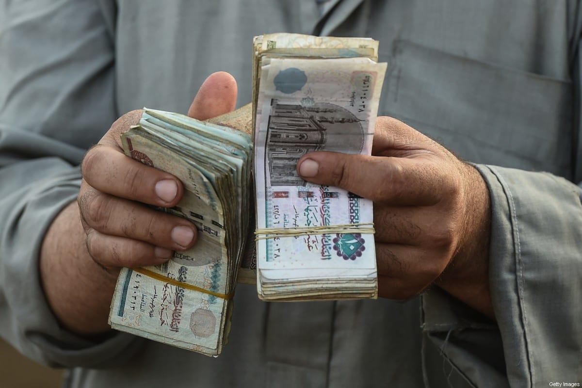 An Egyptian cattle trader counts his money at the Ashmun market [MOHAMED EL-SHAHED/AFP via Getty Images]