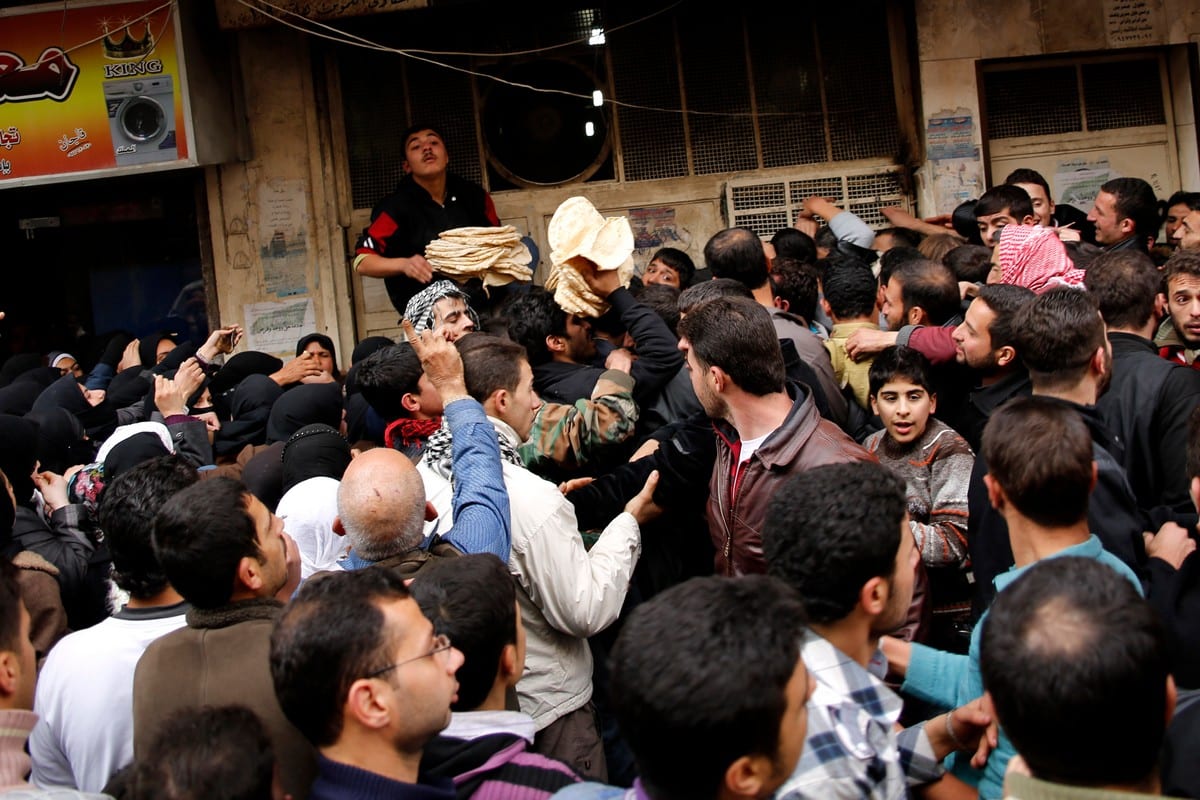 Residents gather around to buy bread in Syria's Aleppo province, on 16 December 2012 [PRASHANT RAO/AFP/Getty Images]