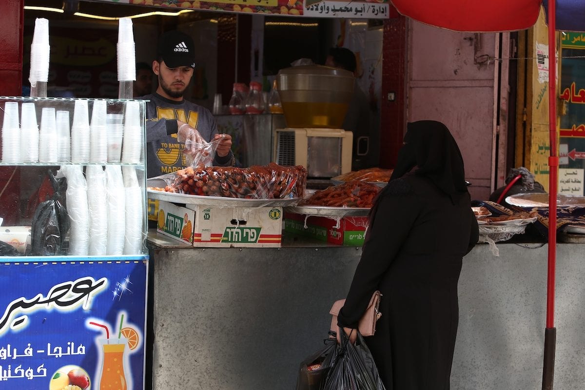 A Palestinian women at a bakery in Gaza on 20 April 2020 [Abed Rahim Khatib/Anadolu Agency]
