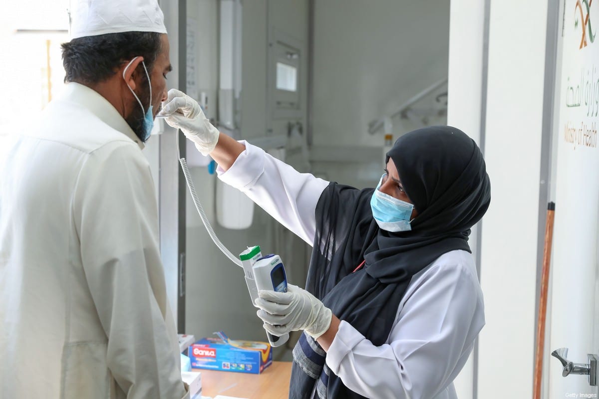 A Saudi nurse checks a patient's temperature at a mobile clinic catering for the residents of Ajyad Almasafi district in the holy city of Mecca, on 7 April, 2020 [BANDAR ALDANDANI/AFP via Getty Images]
