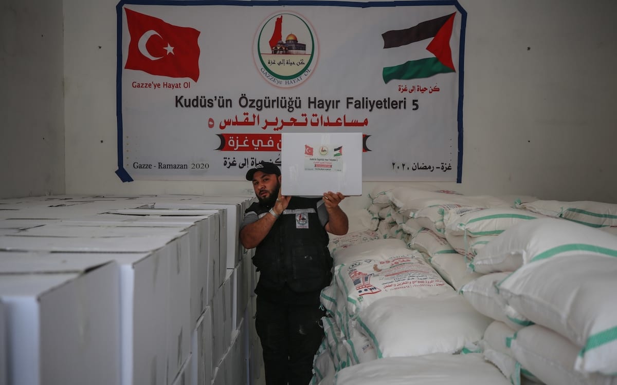 A man carries a box of food aid as Turkey started a campaign to ease problems of 600 families in need on 3 May, 2020 in Gaza City, Gaza [Ali Jadallah/Anadolu Agency]