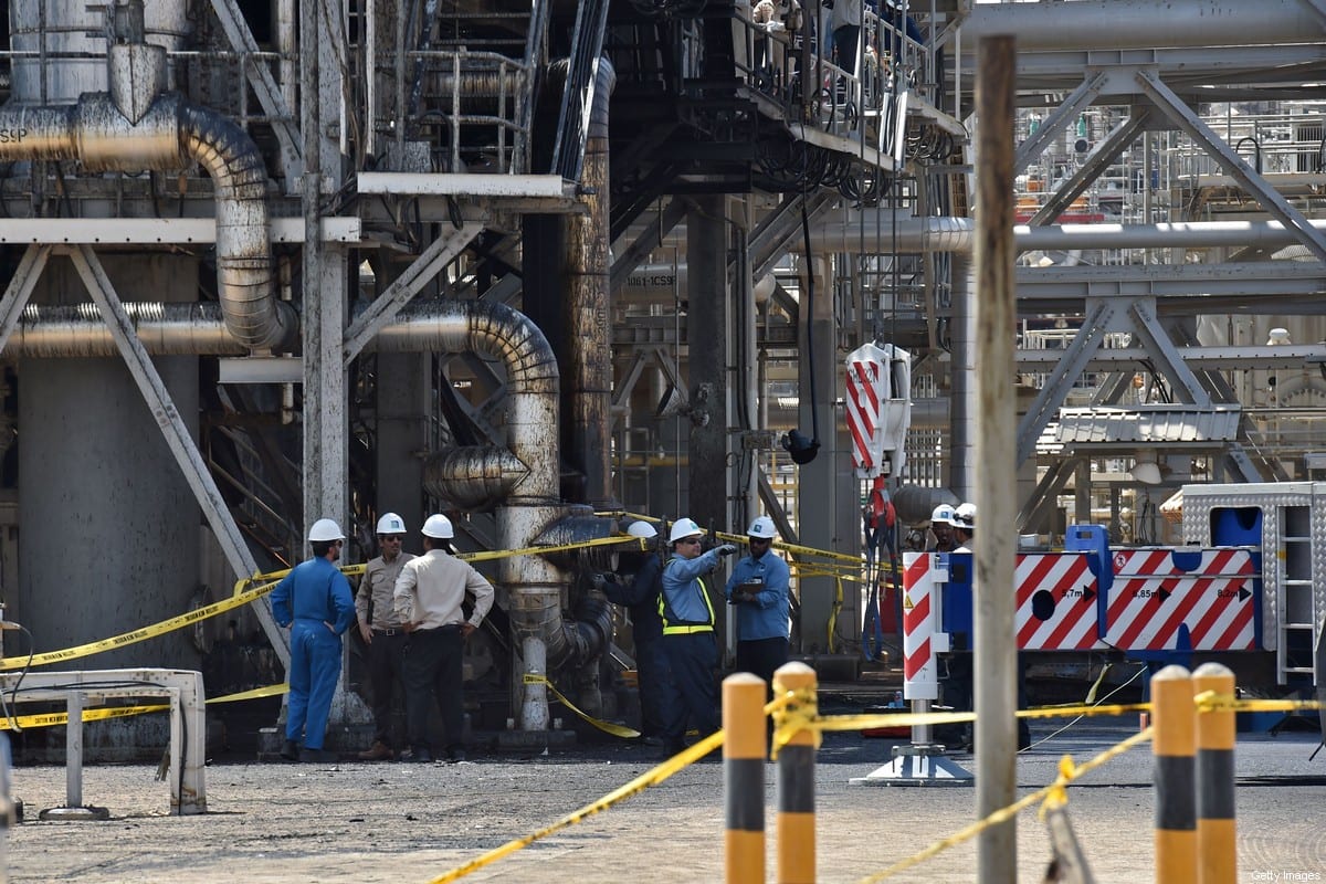 Employes of Aramco oil company stand near a heavily damaged installation in Saudi Arabia's Khurais oil processing plant on 20 September 2019. [FAYEZ NURELDINE/AFP via Getty Images]