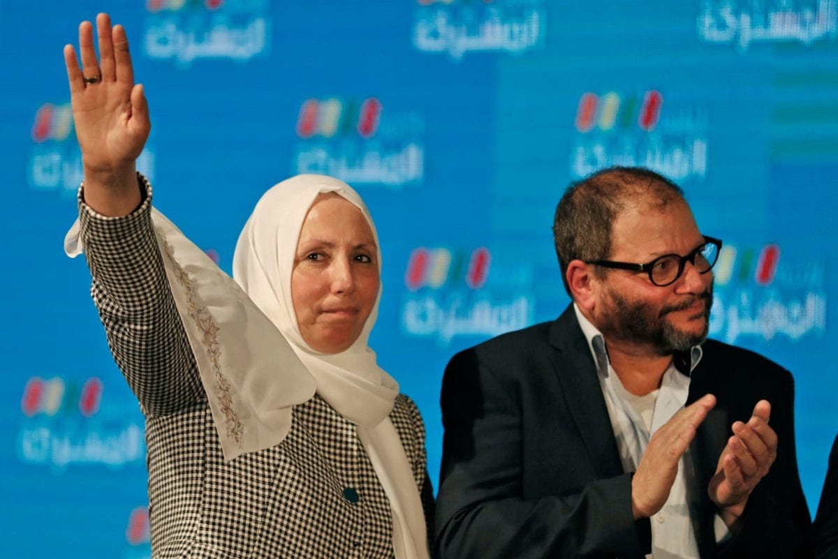 Iman Khatib-Yasin, Israeli-Arab politician representing the Islamic Movement in the Joint List electoral alliance, holds up her hand as she stands next to Ofer Cassif, Jewish member and candidate for the Hadash party within the alliance, as they address supporters at their electoral headquarters in Israel's northern city of Shefa-Amr on March 2, 2020, [AHMAD GHARABLI/AFP via Getty Images]