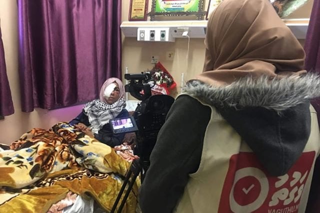 Palestinian journalist Wafaa Aludaini with a Palestinian protester who was shot in the eye during the Great March of Return in Gaza