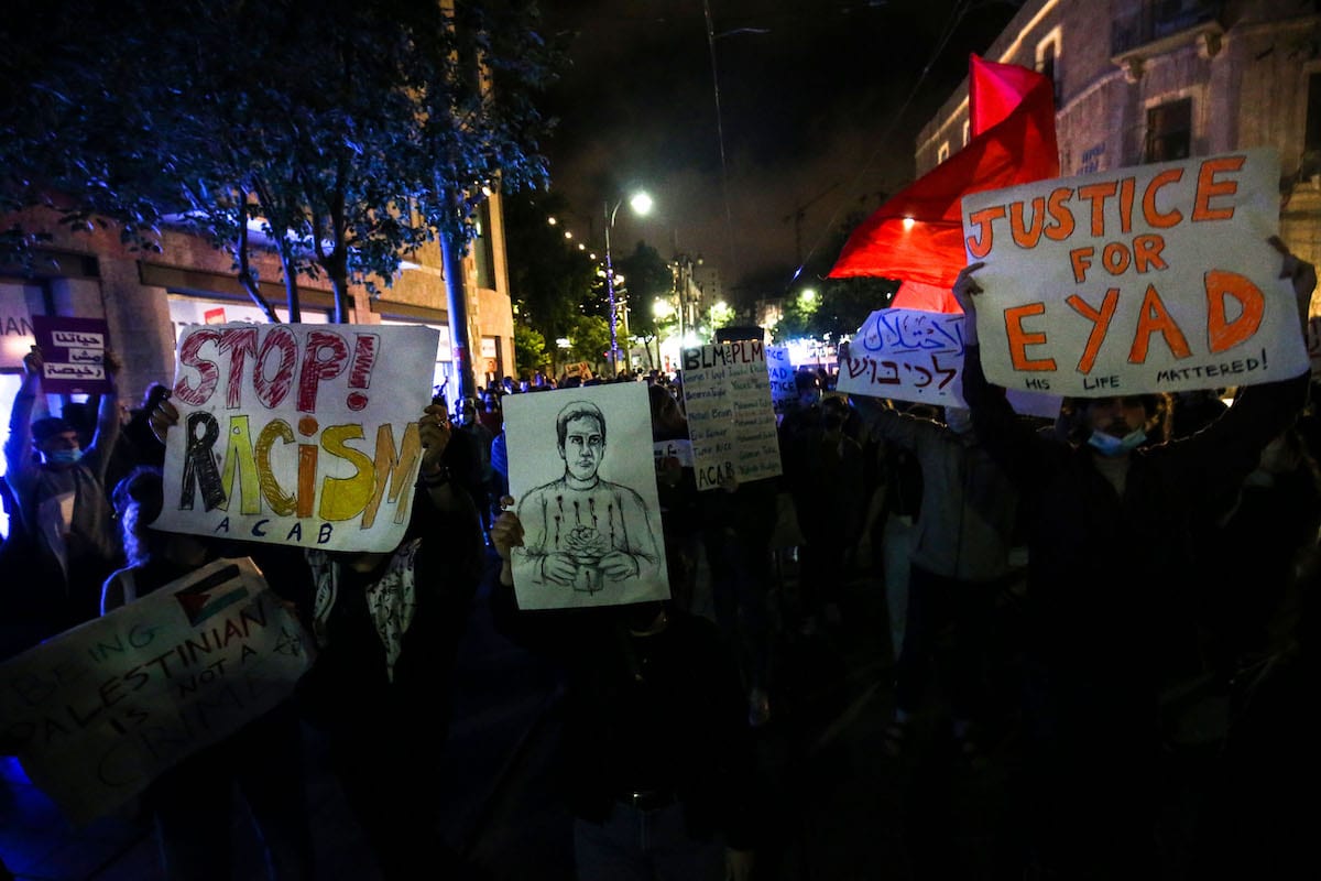 Israelis hold banners during a protest against the shooting dead of Eyad Hallaq, a 32-year-old autistic Palestinian, by Israeli forces at Jaffa Street in Western Jerusalem on June 02, 2020. [Mostafa Alkharouf - Anadolu Agency]