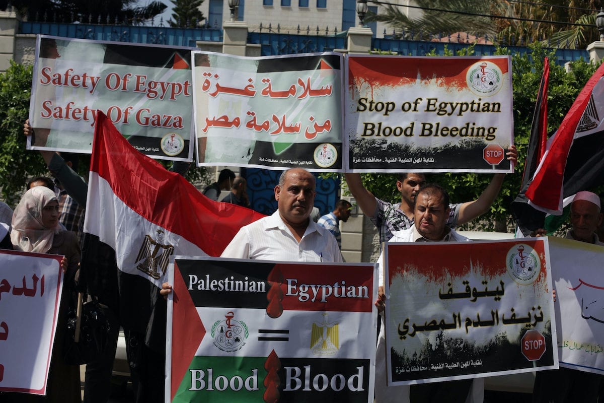 Palestinians protester carry a placard and gestures during a rally in support of ousted Egyptian president Mohamed Morsi, in Gaza City on 19 August 2013. [Ashraf Amra/Apaimages]