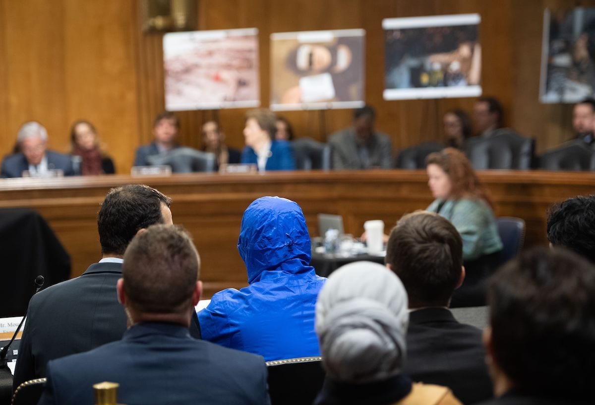 A Syrian military defector using the pseudonym Caesar, while also wearing a hood to protect his identity, testifies about the war in Syria during a Senate Foreign Relations committee hearing on Capitol Hill in Washington, DC, 11 March 2020. [SAUL LOEB/AFP via Getty Images]