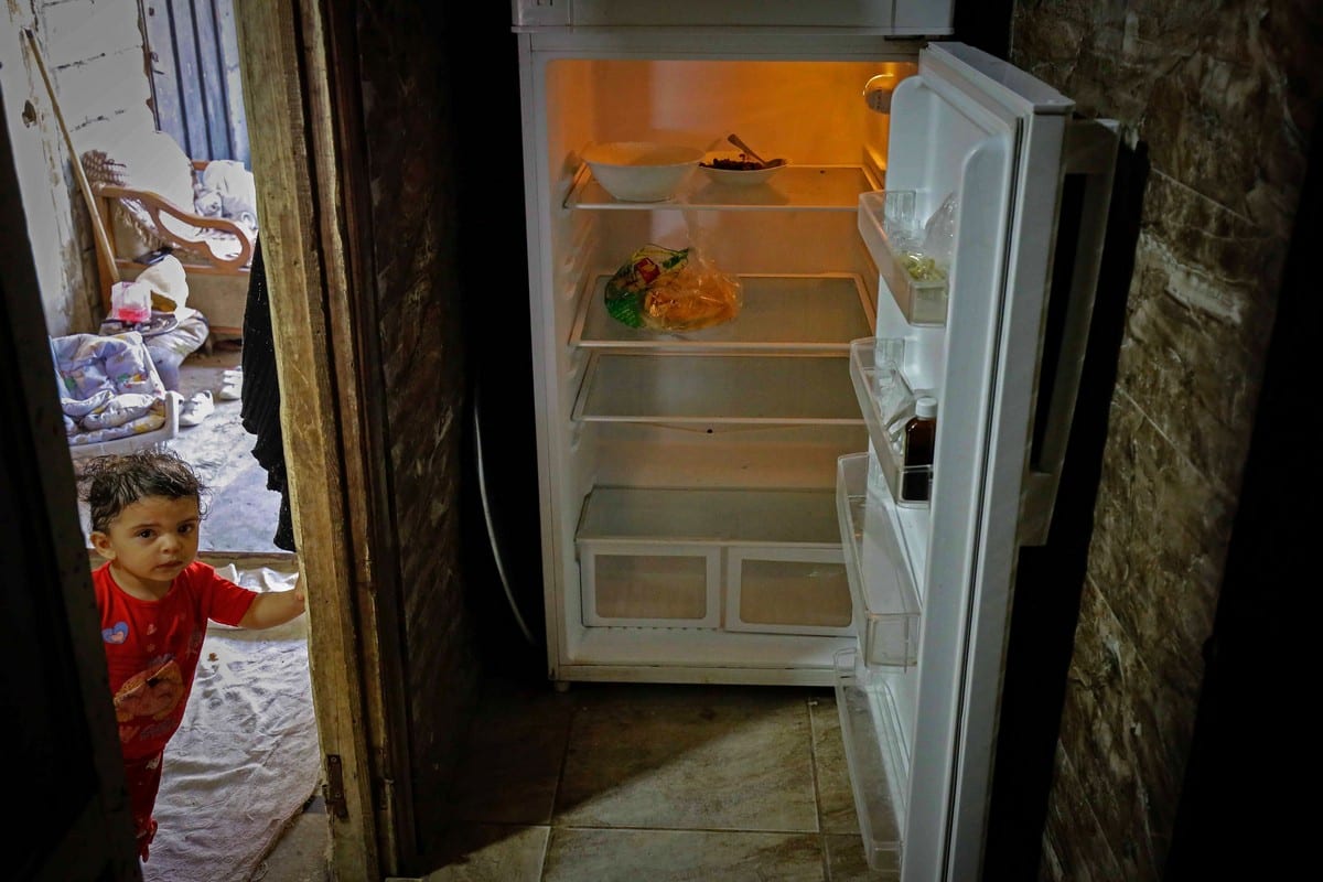 A Lebanese child stands next to an empty refrigerator in Beirut as Lebanon suffers economic crisis plunging many into poverty, 17 June 2020 [IBRAHIM CHALHOUB/AFP/Getty Images]