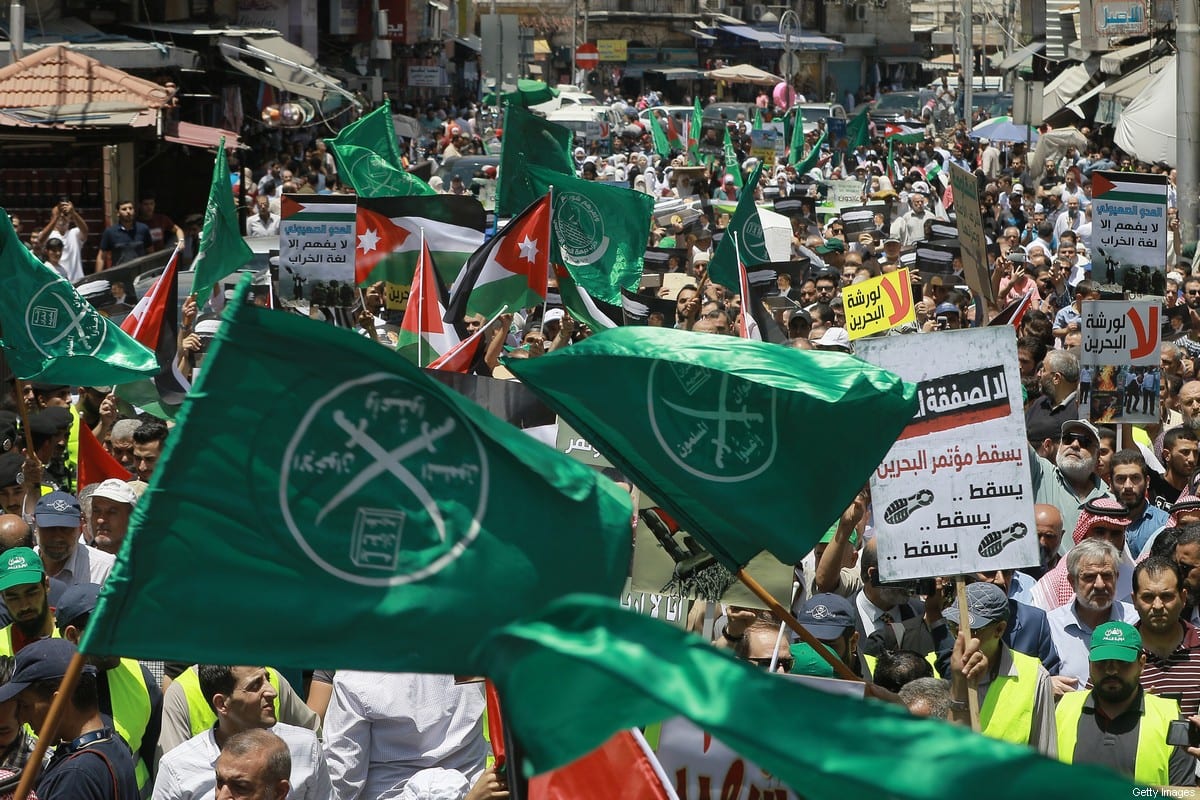 Flags of the Muslim Brotherhood, Jordan, and other political parties are waved with other protest signs denouncing the US-led Middle East economic conference in Bahrain, during a post-Friday prayers demonstration against US President Donald Trump's "Deal of the Century" in the Jordanian capital Amman on June 21, 2019 [KHALIL MAZRAAWI/AFP via Getty Images]