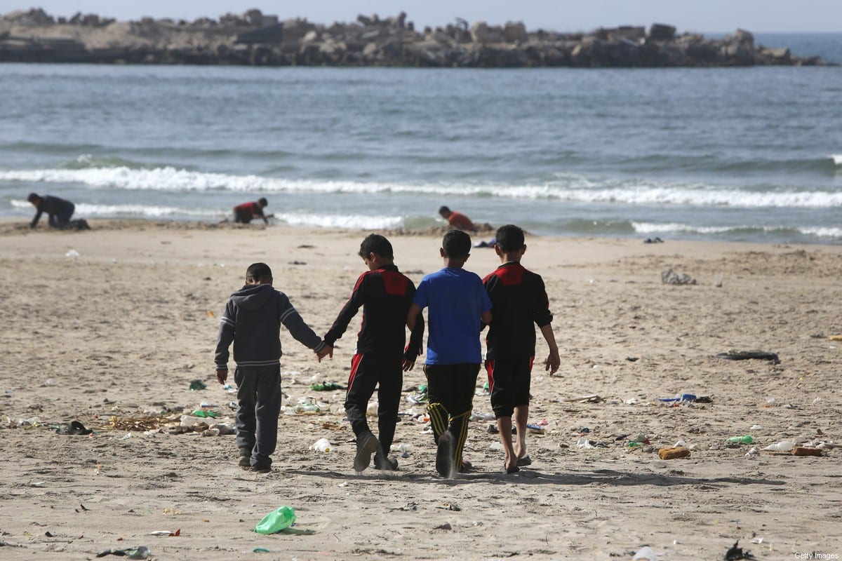 Boys from the Palestinian Bakr family who survived an Israeli attack, killing four children from their family while they were playing at the beach in Gaza City on July 16, 2014, walk on the beach in Gaza City on 29 March 2015 [MAHMUD HAMS/AFP/Getty Images]