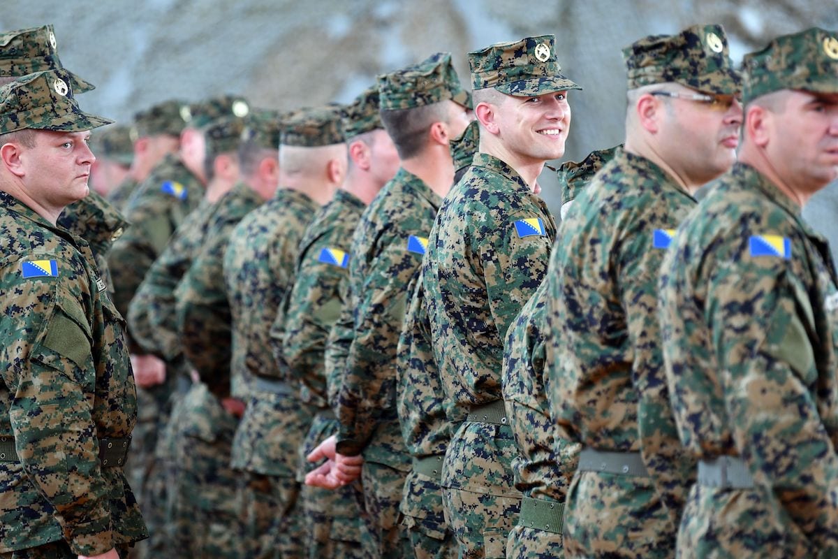 A Bosnian soldier smiles as Bosnian armed forces stand at attention during a ceremony in Capljina, on 12 June 2019. [ELVIS BARUKCIC/AFP via Getty Images]