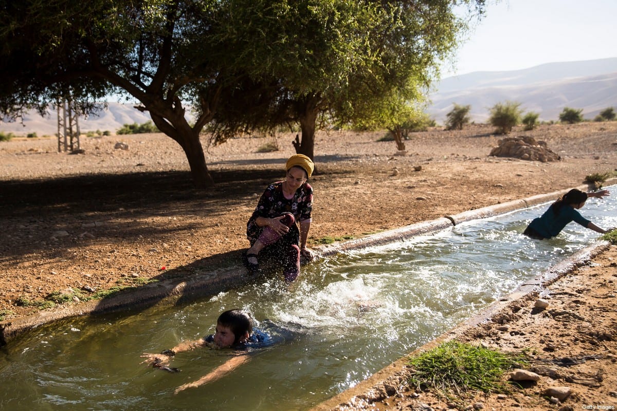 A Jewish settler family swims in the water of the natural spring of Ein Al-AUJA in the occupied Jordan Valley West Bank on 24 June 2020 [Amir Levy/Getty Images]