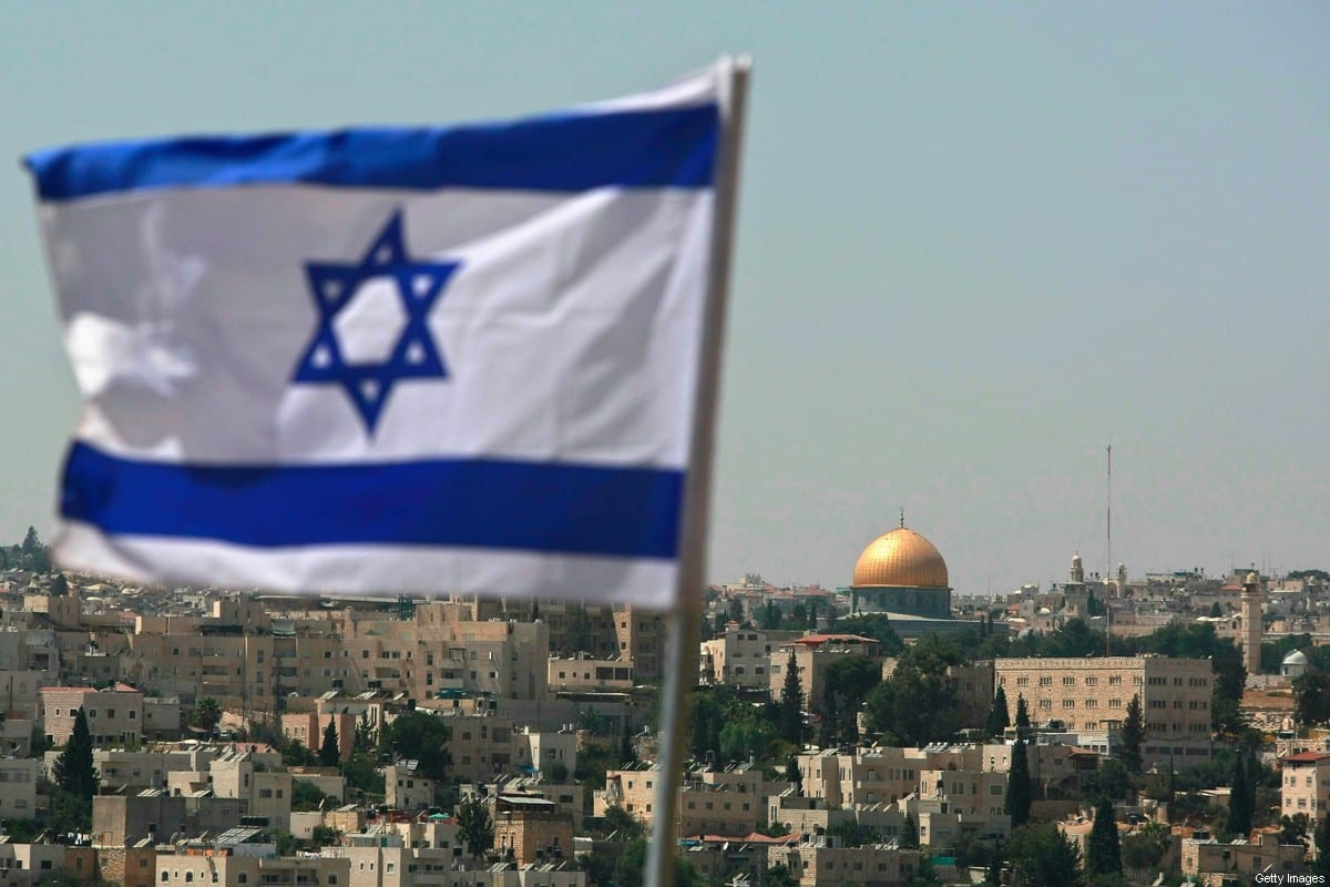 An Israeli flag flies from the Kidmat Zion Israeli settlement on the outskirts of the Palestinian village of Abu Dis, where the Old City with its golden Dome of the Rock is seen in the background, August 18, 2008 in East Jerusalem, Palestine [David Silverman/Getty Image]