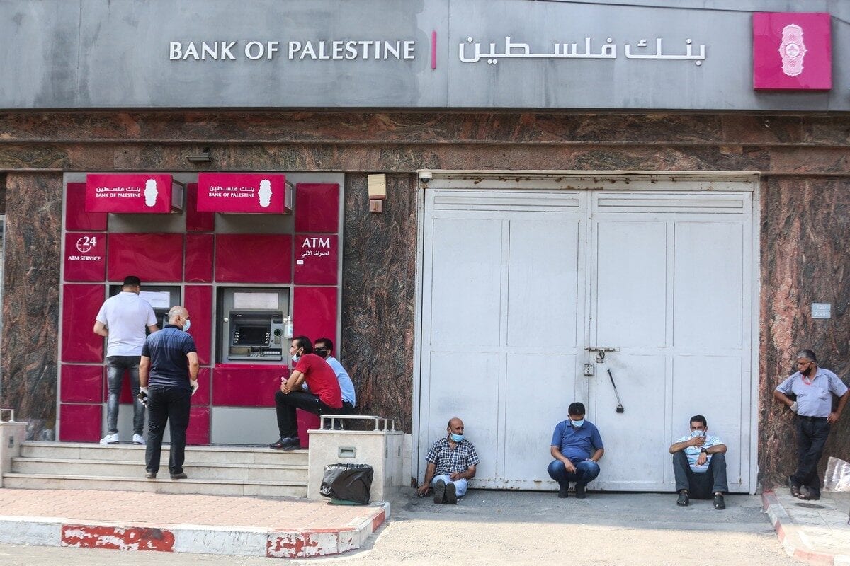 Palestinians wearing protective masks maintain social distancing while waiting in ATM line during the coronavirus (COVID-19) pandemic in Gaza City, Gaza on 1 September 2020. [Ali Jadallah - Anadolu Agency]