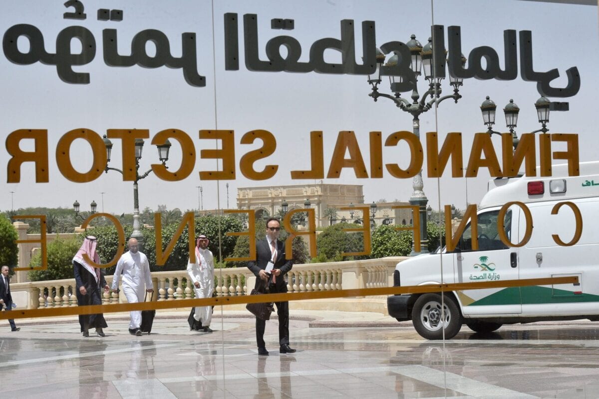 Saudi participants pass by a sign of the Financial Sector Conference held in Riyadh, on April 24, 2019. [FAYEZ NURELDINE/AFP via Getty Images]