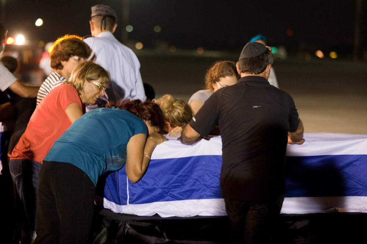 Relatives mourn over the coffin of one of the five Israelis who were killed during the terror attack on a tour bus in Burgas, Bulgaria, during a ceremony at the Ben Gurion International Airpor on July 20, 2012 near Tel Aviv, Israel. [Uriel Sinai/Getty Images]