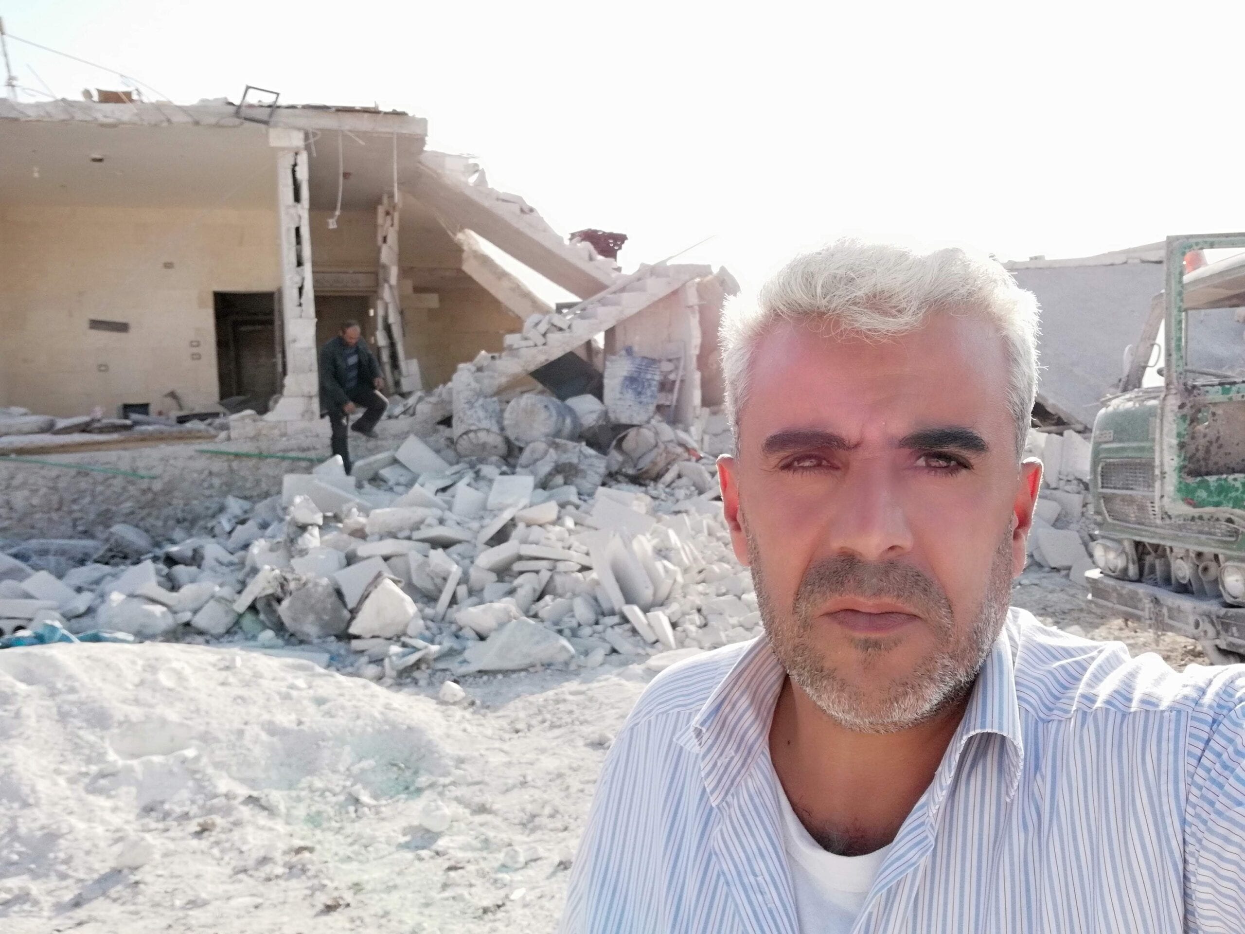 Dergham Hammadi in front of a civilian home bombed by the regime