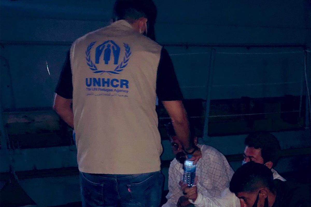 A UNHCR worker with asylum seekers who were at sea [UNHCRLibya/Twitter]