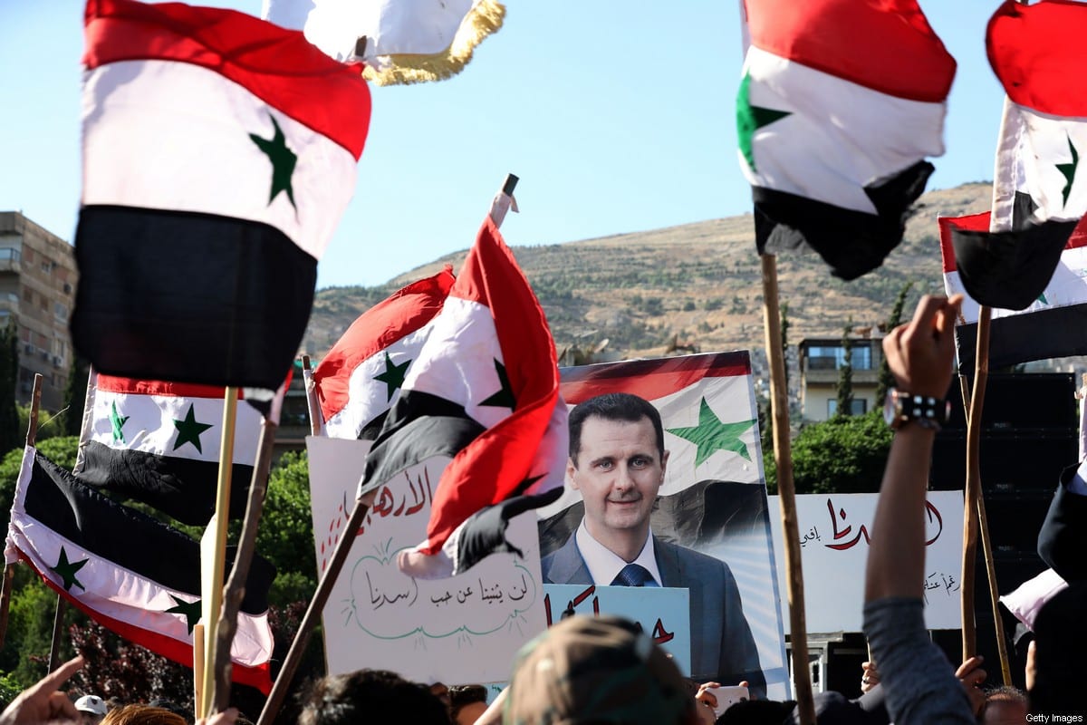 People wave Syrian national flags and pictures of President Bashar al-Assad as they gather for a demonstration, at the Umayyad Square in the centre of the capital Damascus on June 11, 2020 [LOUAI BESHARA/AFP via Getty Images]