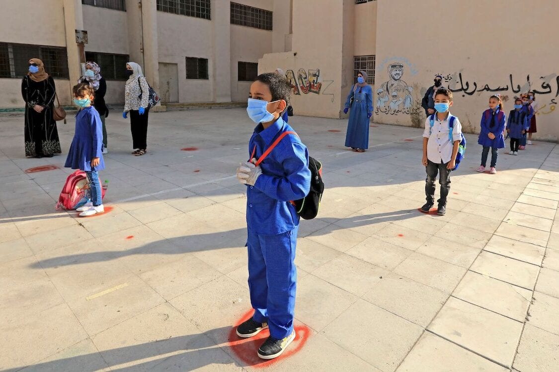Students, wearing protective masks, wait in line on the first day of school in the Jordanian capital Amman amid the ongoing COVID-19 pandemic, on 1 September 2020. [KHALIL MAZRAAWI/AFP via Getty Images]