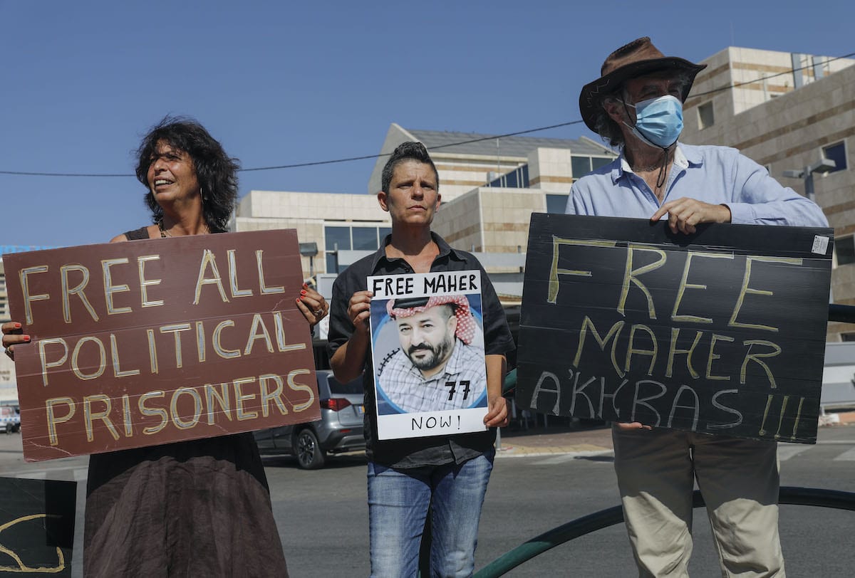 Israeli left-wing activists lift placards during a demonstration calling for the release of Palestinian administrative detainees, including Maher al-Akhras who's health has deteriorated while on hunger strike for 77 days, in front of Kaplan medical center where he is in Israeli custody in the central city of Rehovot, on 11 October 2020. [AHMAD GHARABLI/AFP via Getty Images]