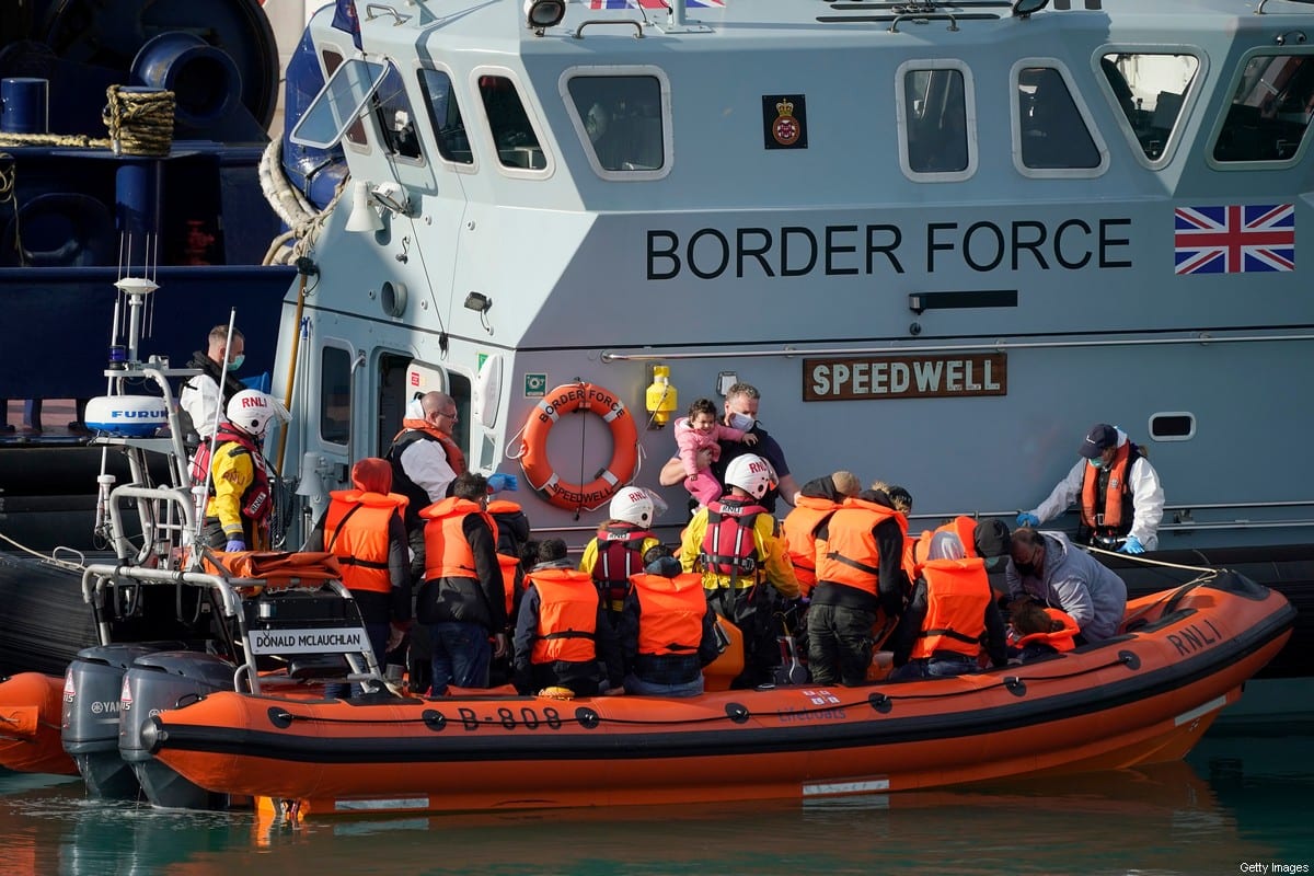 A young girl is held by a member of the border force at Dover Marina after being rescued in the English Channel by the RNLI on September 07, 2020 in Dover, England [Christopher Furlong / Getty Images]