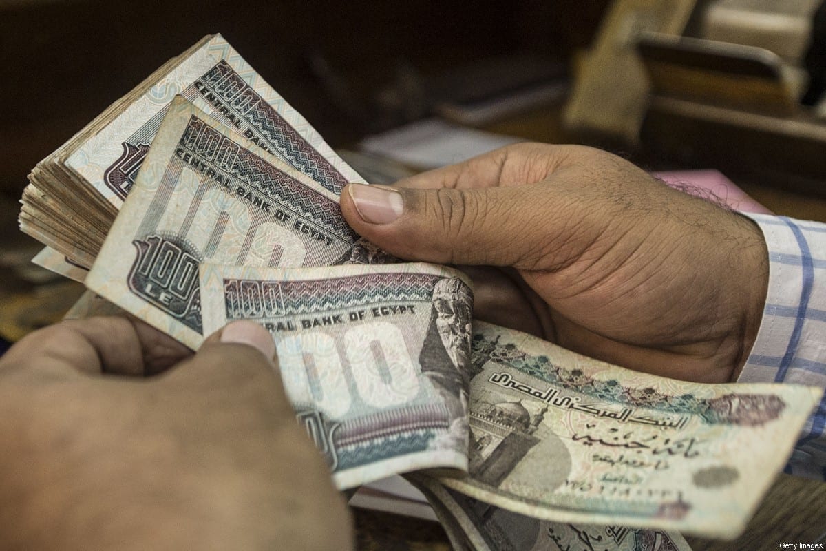 A man counts Egyptian pounds at currency exchange shop in downtown Cairo. [Photo by KHALED DESOUKI/AFP via Getty Images]