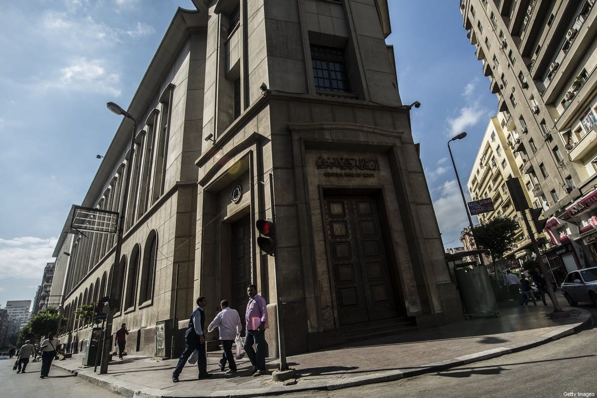 People walk past the Egyptian Central Bank in downtown Cairo on 3 November 2016. [KHALED DESOUKI/AFP via Getty Images]