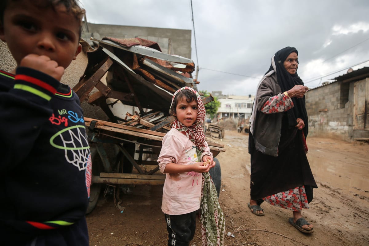 Children are seen at muddy road after rainfall in Gaza City, Gaza on 5 November 2020 [Mustafa Hassona/Anadolu Agency]