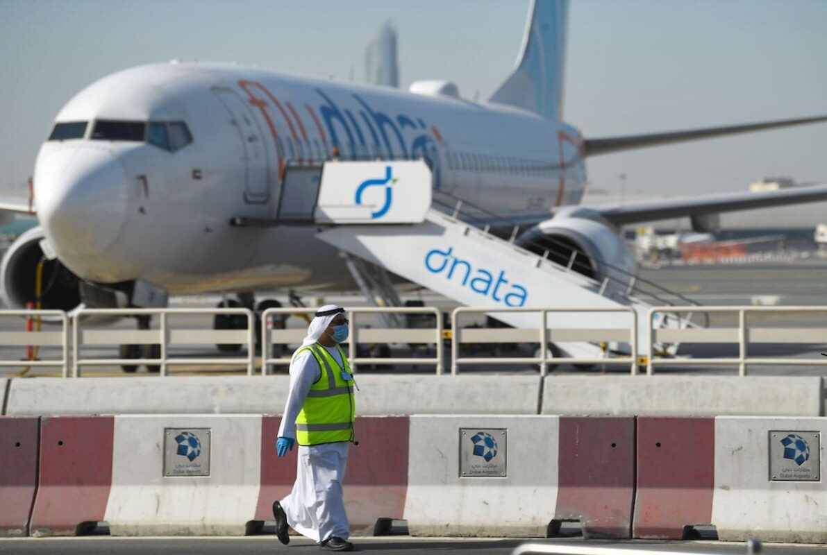 A mask-clad employee walks across a Flydubai aircraft on the tarmac of Dubai International Airport, on 6 April 2020. [KARIM SAHIB/AFP via Getty Images]