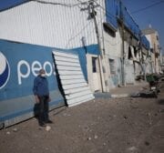 Damage to a soft drinks warehouse, seen after Israeli fighter jets attacked Gaza City, Gaza on December 26, 2020 [Mohammad Asad / Middle East Monitor]
