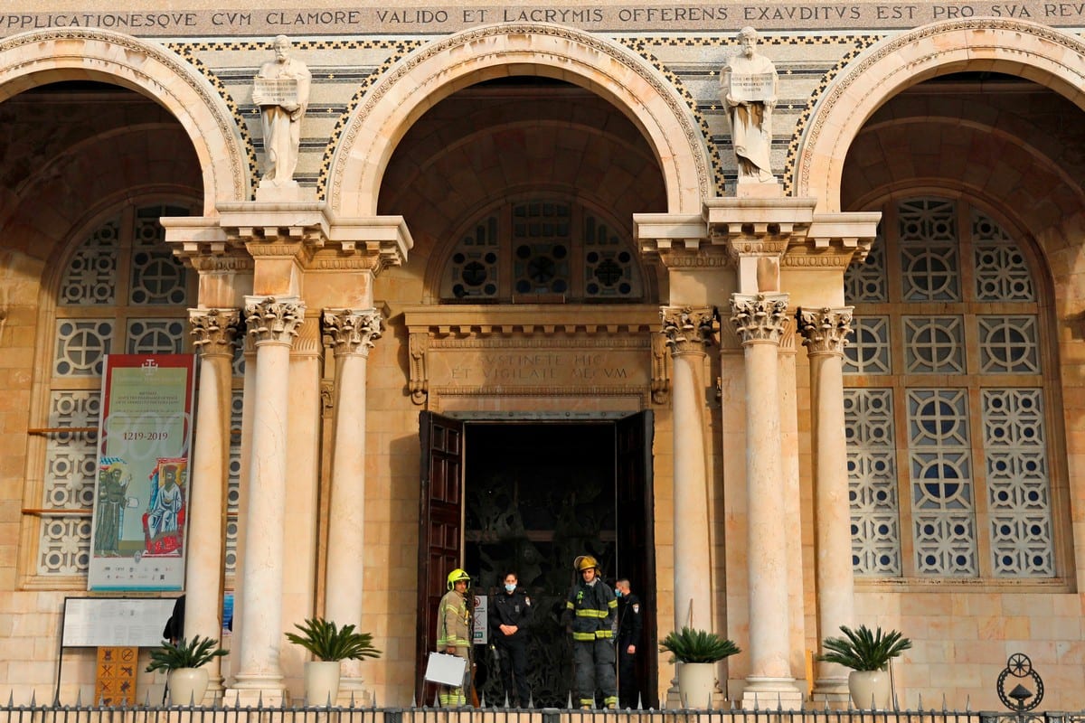 Israeli police and firefighters stand outside the Gethsemane Church in Jerusalem after settlers attempted to set fire to the holy site [AHMAD GHARABLI/AFP/Getty Images]