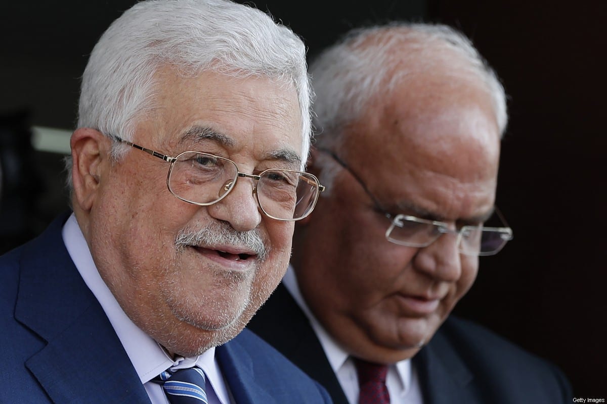 Palestinian President Mahmoud Abbas (L) walks with Palestine Liberation Organisation secretary-general Saeb Erekat during their visit to the Pilgrims City, in the West Bank town of Jericho on August 6, 2018. [AHMAD GHARABLI/AFP via Getty Images]
