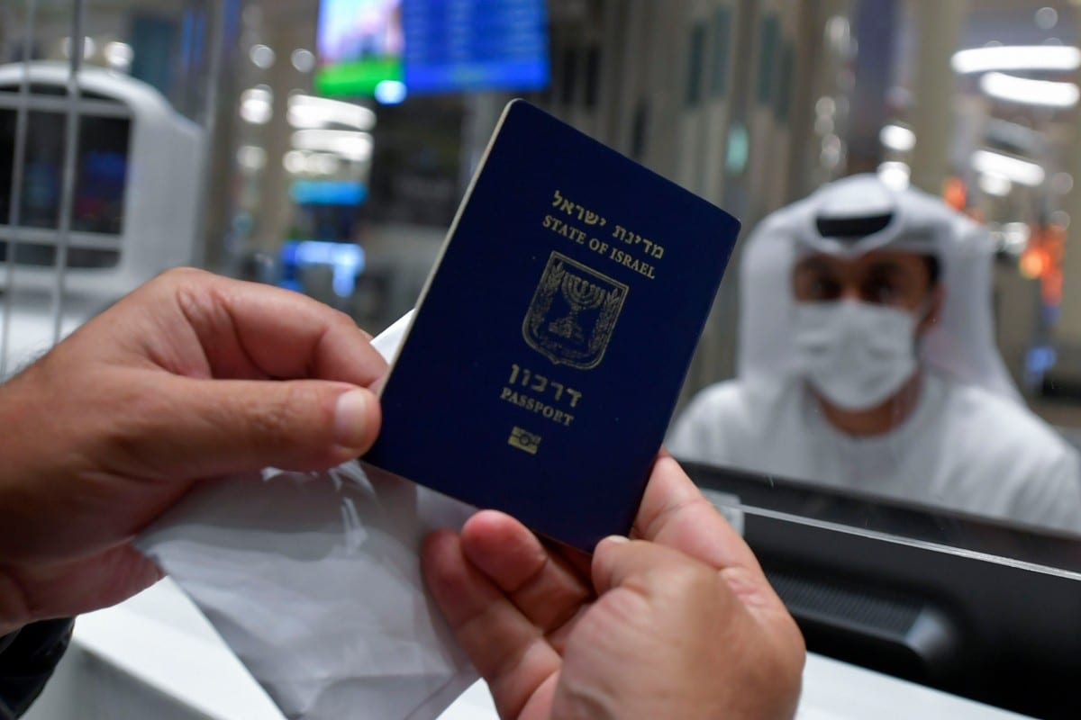 An Israeli man presents his passport for control upon arrival from Tel Aviv to the Dubai, UAE on 26 November 2020 [KARIM SAHIB/AFP/Getty Images]